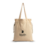 Sac fourre-tout beige à cordon en coton avec le logo Bibaelin et un dessin d'éléphant sur fond blanc | Beige cotton drawstring tote bag featuring the Bibaelin logo and an elephant illustration on a white background.