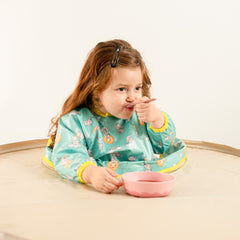 Vue d'ensemble du bavoir bleu-vert offrant une protection totale contre les éclaboussures | Overall view of the teal bib offering full splash protection in a high chair