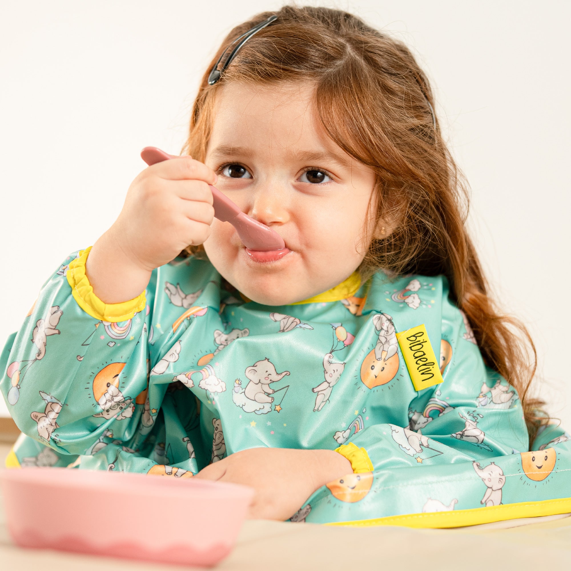 Gros plan d'un enfant mangeant proprement avec le bavoir imperméable facile à nettoyer | Close-up of a child eating cleanly with the easy-to-clean waterproof bib