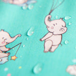 Gros plan sur le tissu imperméable du bavoir bleu-vert montrant l'effet déperlant des gouttes d'eau. | Close-up of teal bib waterproof fabric showing water repellent effect.