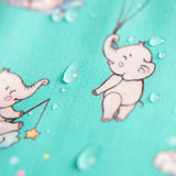 Gros plan sur le tissu imperméable du bavoir bleu-vert montrant l'effet déperlant des gouttes d'eau. | Close-up of teal bib waterproof fabric showing water repellent effect.