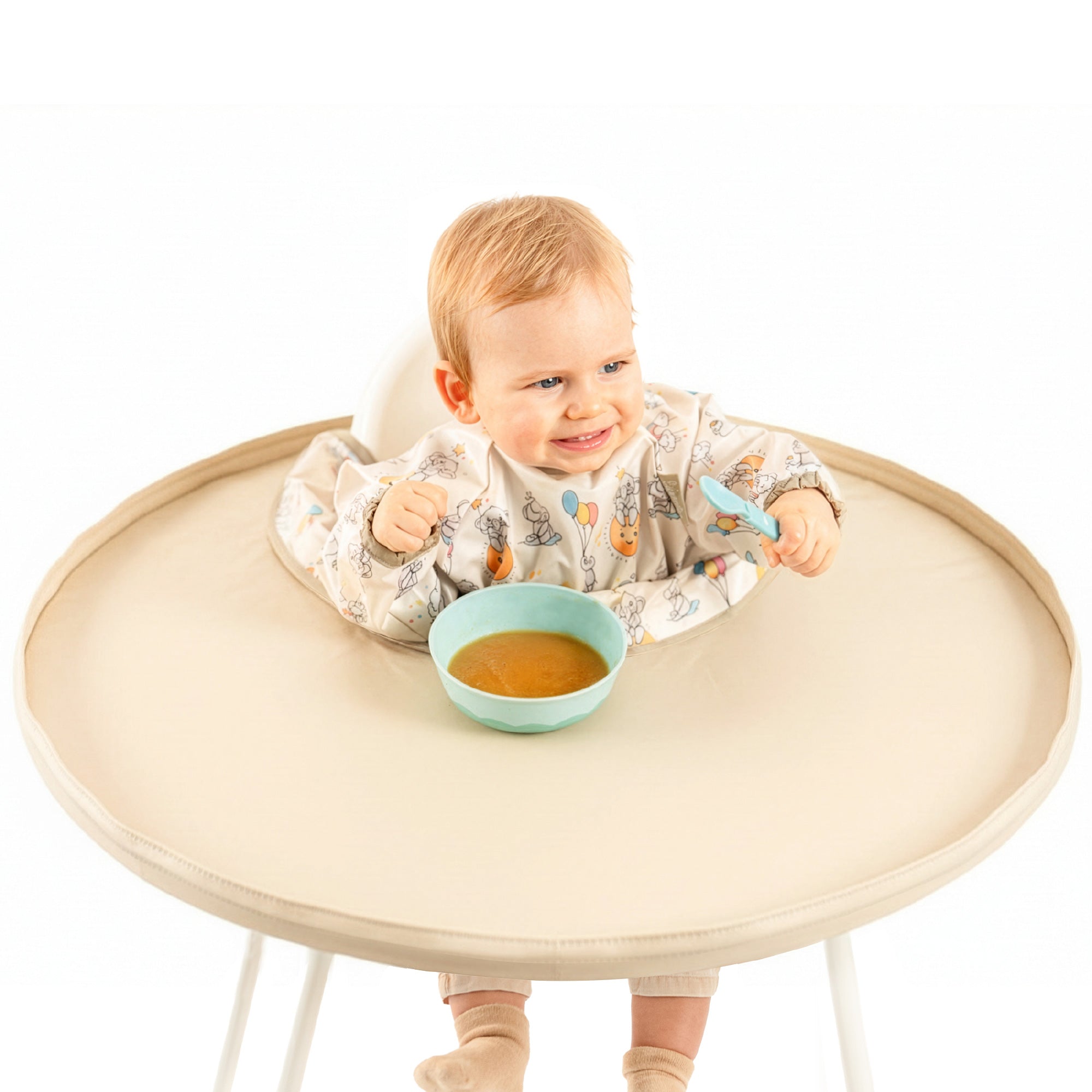 Bébé mangeant avec le kit bavoir plateau intégral Bibatray-M beige Bibaelin | Baby eating with full beige bib tray kit.